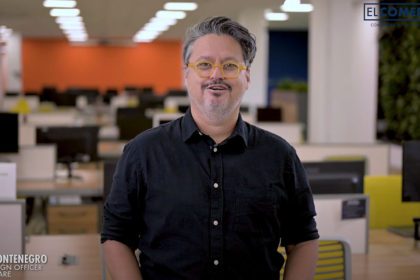 Headshot of Dana Montenegro standing in an open office space